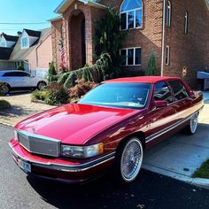 a red car parked in front of a house