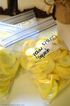 two bags filled with sliced bananas sitting on top of a white table next to a plant