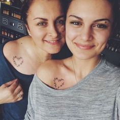 two women with tattoos on their chest posing for the camera