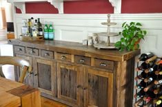 an old wooden buffet with wine bottles on it