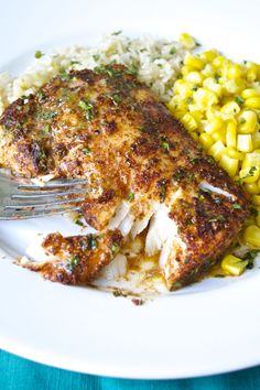 a white plate topped with chicken, rice and corn