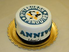 a birthday cake with an image of a penguin on the frosting and blue lettering