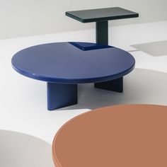 a blue table sitting on top of a white floor next to a brown and orange chair