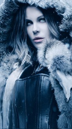 black and white photograph of a woman wearing a leather jacket with fur on the hood