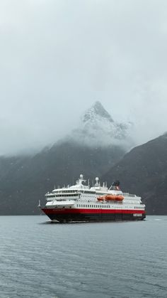 a large cruise ship in the water with mountains in the background