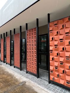 several orange boxes are lined up on the side of a building with black metal posts