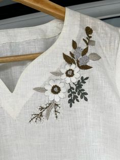 an embroidered white shirt with flowers on it