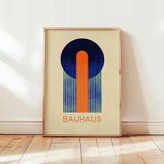 a framed poster with the word bauhaus on it in front of a white wall