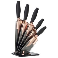 a set of knives with black handles and rose gold tips in a holder on a white background