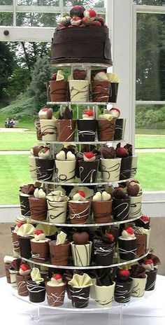 a tower of cupcakes with chocolate frosting and strawberries on each tier