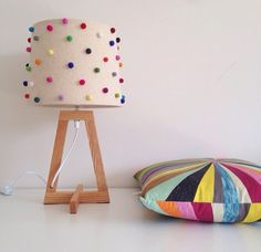 a lamp that is on top of a table next to a pillow and a pillow