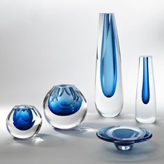 blue glass vases and plates on a white surface