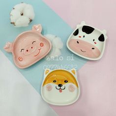 three plates with animals on them sitting next to cotton