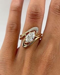 a woman's hand with a diamond ring on top of her finger and an engagement band