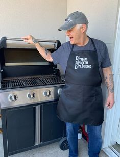 an older man wearing an apron pointing at the grill