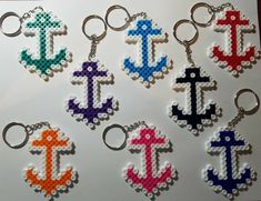 six cross stitch keychains with different colors and designs on them, all made out of plastic beads