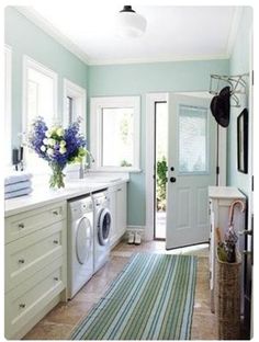 a washer and dryer are in the middle of a room with blue walls