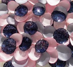 some pink and blue flowers on a wooden table with glittery petals in the center