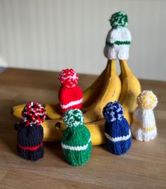 several knitted hats and bananas on a table