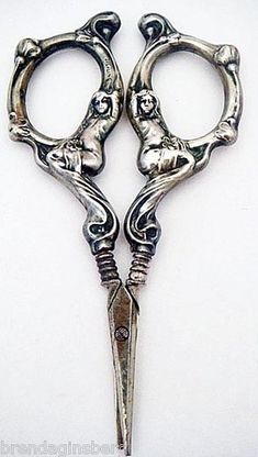 two pairs of scissors sitting next to each other on a white surface with the handles open