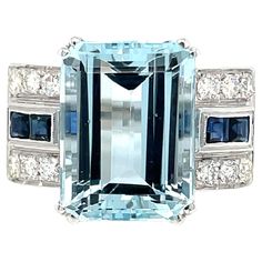 Art Deco style ring set in the center with a stunning Aquamarine weighing 11,54 carats graded AAA, and surrounded by approx. 0.50 carat of custom cut Sapphires and 0.65 ct of round brilliant cut diamonds graded G Color Vvs Clarity, Remarkable gallerias work. Circa 1940 CONDITION: Pre-owned - Excellent METAL: 18k gold GEM STONE: Aquamarine 11,54 ct - Sapphire ct 0,50 - Diamond 0.65 ct RING SIZE: US 7/7,5 - IT 15 - FR 55- UK O, Resizable on request, free of charge GROSS WEIGHT: 10,25 grams * every jewel we propose for sale is professionally tested by our internal gemological team of specialist I.G.I./HRD - ** the jewel comes with Gemological appraisal and warranty in a nice ring box For any further information or enquires please don't hesitate to contact us Sapphire Gold Ring, Cut Rings, Emerald Cut Rings, Diamond Rings Bands, Deco Jewelry, Gem Stone, Art Deco Style, Round Brilliant Cut Diamond, Ring Box