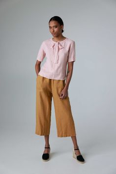 "Get comfortable in these relaxed, slightly flared linen culottes. These wide leg trousers have elastic waist and side pockets. The pockets are accented with decorative seams. The pants would serve you well on all casual occasions or around your house. They can be easily paired with a kimono jacket and an oversized blouse. Made from heavy linen for more solid look and feel. STYLE DETAILS * Relaxed fit * Elastic waist * 2 side pockets * Slightly flared at the bottom * Cropped (ankle length) * Made from heavy linen SIZES & COLORS IN PICTURES * Model 1 wears size S/M in color Honey Yellow. She is 178 cm (5'10\"). Bust - 85 cm (33\"), waist - 63 cm (25\"), hips - 86 cm (34\"). * Model 2 wears size S/M in color Pearl Grey. She is 176 cm (5'9\"). Bust - 83 cm (33\"), waist - 60 cm (24\"), hips - Linen Culottes, Decorative Seams, Cropped Linen Trousers, Honey Yellow, Trousers For Women, Oversized Blouse, Wide Leg Linen Pants, Pants With Pockets, Linen Trousers