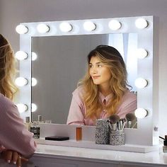 a woman is looking at herself in the mirror