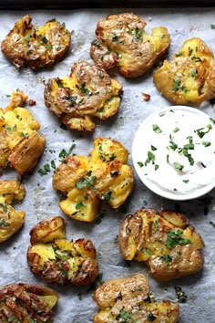 baked potatoes on a baking sheet with ranch dressing