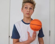 a young boy holding a basketball in his hand