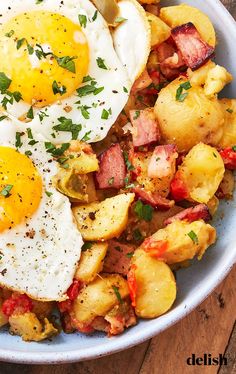 two fried eggs on top of potatoes in a bowl