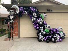 a house decorated for halloween with balloons in the shape of a letter d and skeletons