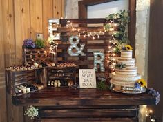 a wooden table topped with a cake and lots of desserts on top of it