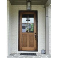 the front door is made of wood and has a lantern on it's side