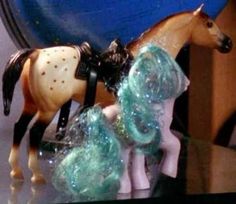 two plastic horses on top of a glass shelf