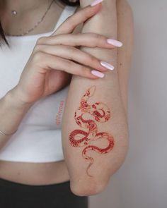 a woman is holding her arm with a tattoo on it's left shoulder and hand