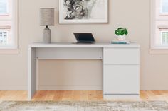 a white desk with a laptop on it in front of two windows and a rug