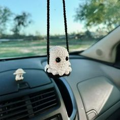 a small stuffed animal hanging from the dashboard of a car