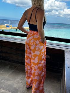 Take a walk on the sunny side with these Feeling Tropical Flowy Wide Leg Pants! With an elastic waistband and adjustable drawstring, these lightweight, sun-ready pants are perfect for any outdoor adventure. Featuring a wide-leg fit and all-over tropical prints, these amazing pants will make you look fabulous while you have fun in the sun! Color: Orange Tropic Fabric: 100% Polyester Brand: Lumiere Includes: x1 Pair of Pants Sizes: S-M-L, Regular Sizing Model is 5'9" and wearing a size Small Sun Color, Flowy Wide Leg Pants, Tropical Orange, Tropical Prints, Take A Walk, Pair Of Pants, Tropical Print, Outdoor Adventure, Walk On