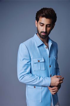 Editor's Note Introducing a charming light blue bandhgala featuring a patch pocket design. The light blue color adds a subtle and soothing touch to the ensemble, while the patch pocket detail adds a contemporary and functional element. The bandhgala jacket exudes a sophisticated and refined style, making it a versatile choice for various occasions. Perfectly tailored and effortlessly stylish, this light blue bandhgala with a patch pocket is sure to elevate your formal or semi-formal attire with Semi-formal Blue Blazer With Patch Pockets, Blue Semi-formal Blazer With Patch Pockets, Semi-formal Blue Blazer With Button Cuffs, Blue Semi-formal Sets With Pockets, Formal Cotton Sets With Pockets, Blue Long Sleeve Bandhgala For Semi-formal Occasions, Semi-formal Blue Sherwani, Blue Cotton Long Sleeve Bandhgala, Blue Cotton Long-sleeve Bandhgala