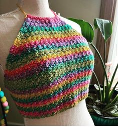 a close up of a mannequin's torso wearing a multicolored knitted sweater