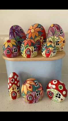 several colorfully painted rocks sitting on top of a blue container next to each other