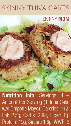 two crab cakes with mayonnaise and lettuce on top, sitting on a bed of lettuce