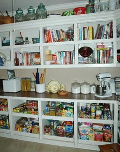 a kitchen filled with lots of different types of food and cooking utensils on top of white shelves