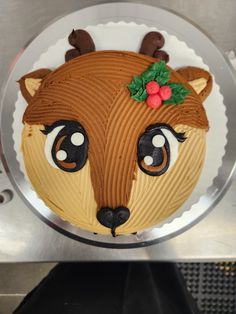 there is a cake that looks like a reindeer's head with holly on it