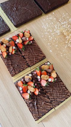 three chocolate squares with strawberries and nuts on them