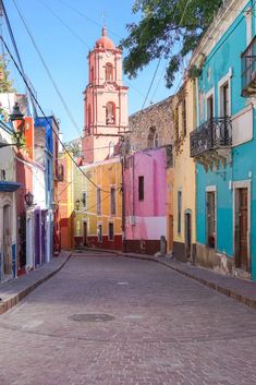 an empty street with colorful buildings in the background