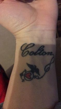 a person with a tattoo on their wrist that says,'golden'and is holding a cell phone up to her ear