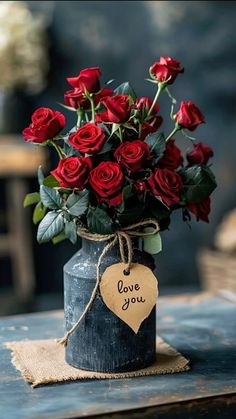 a bouquet of red roses in a vase with a tag that says i love you