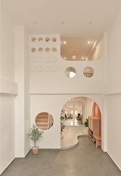 the inside of a house with white walls and concrete flooring that has circular holes in it