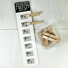 wooden clothes pegs are next to a plastic container with match letters on the side